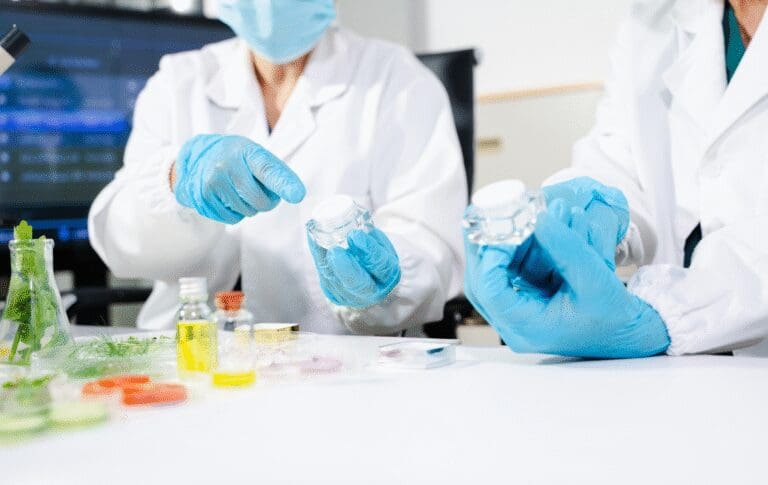 Laboratory professionals evaluating cosmetic packaging and product samples during quality testing.