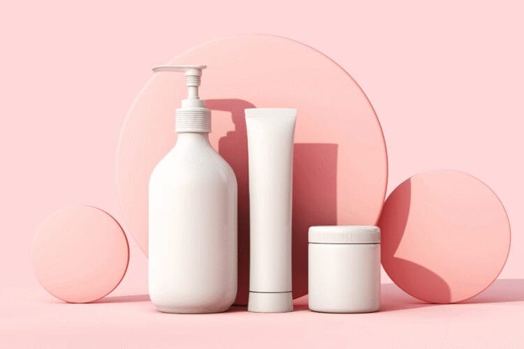Minimalist cosmetic packaging including a lotion bottle, skincare tube, and cream jar on a pink background