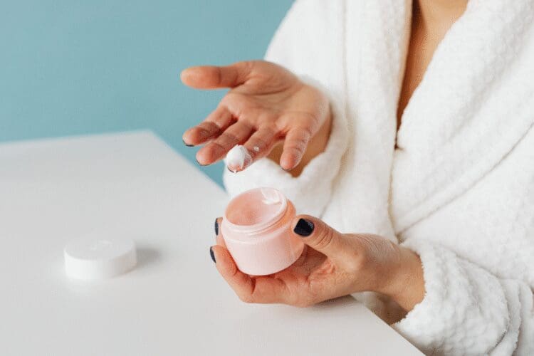 Person applying facial moisturizer as part of a daily skincare routine.