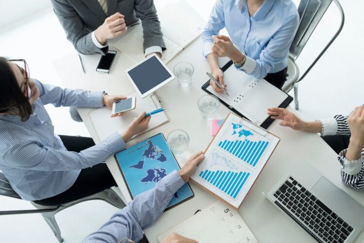 Business professionals discussing international regulatory compliance and market access strategies during a meeting.