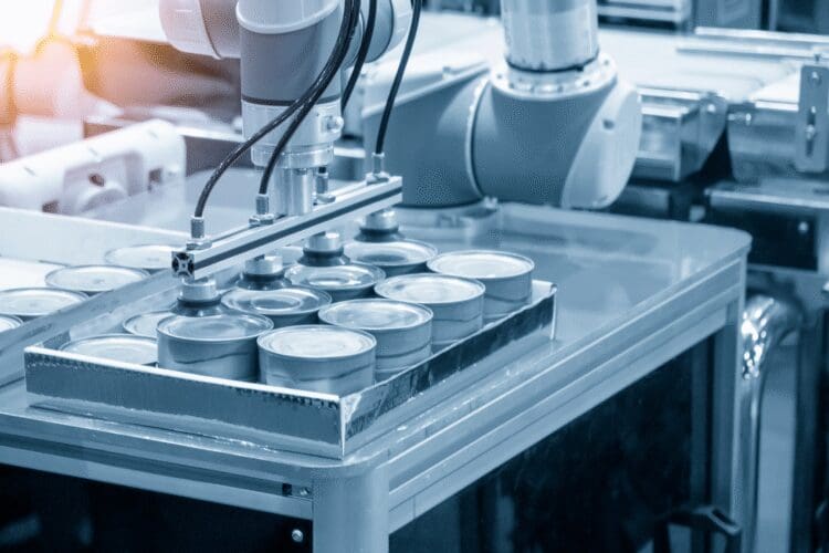 Automated industrial production line handling metal containers in a manufacturing facility.