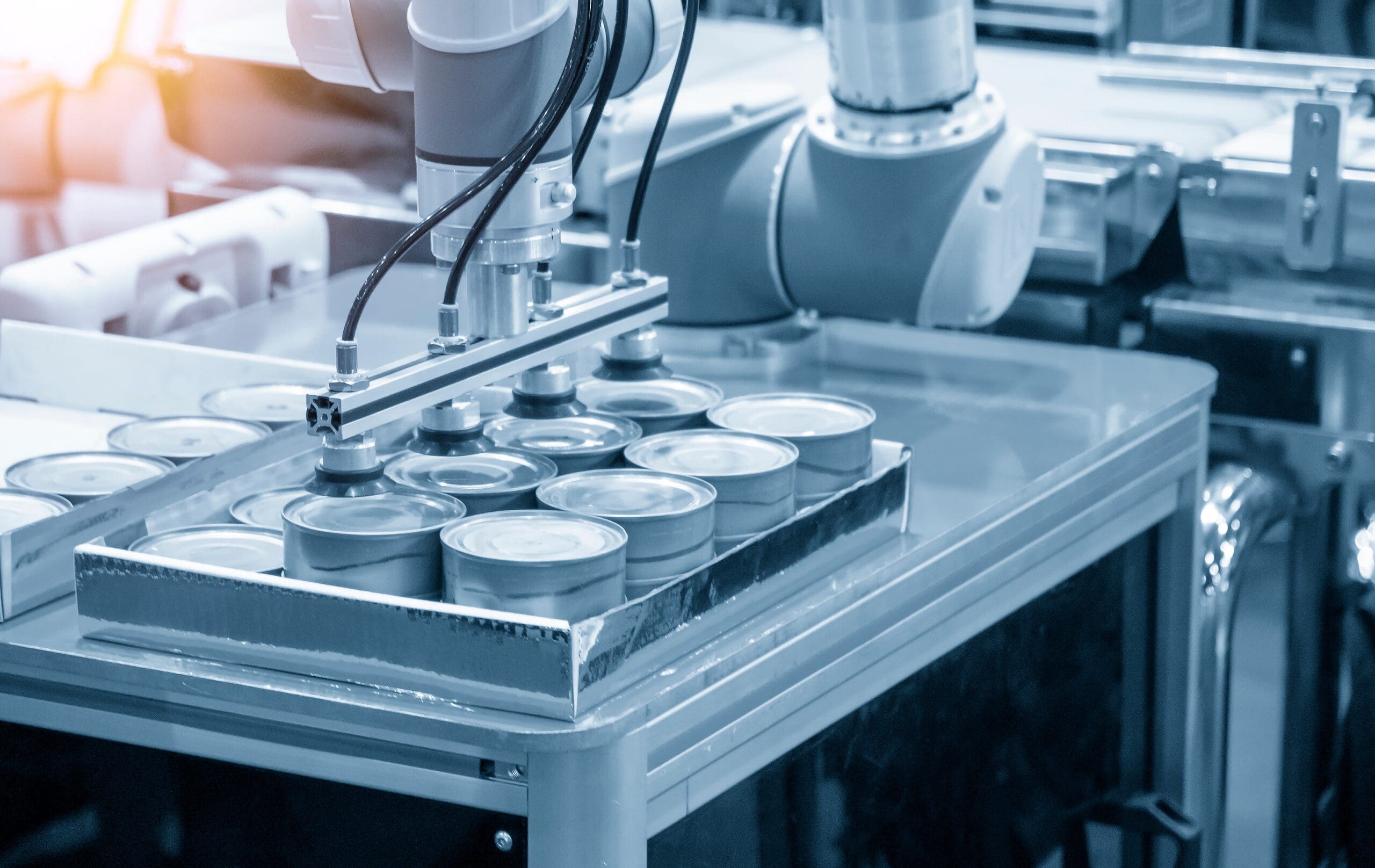 Automated industrial production line handling metal containers in a manufacturing facility.