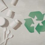 Recycling symbol surrounded by plastic packaging and disposable plastic products.